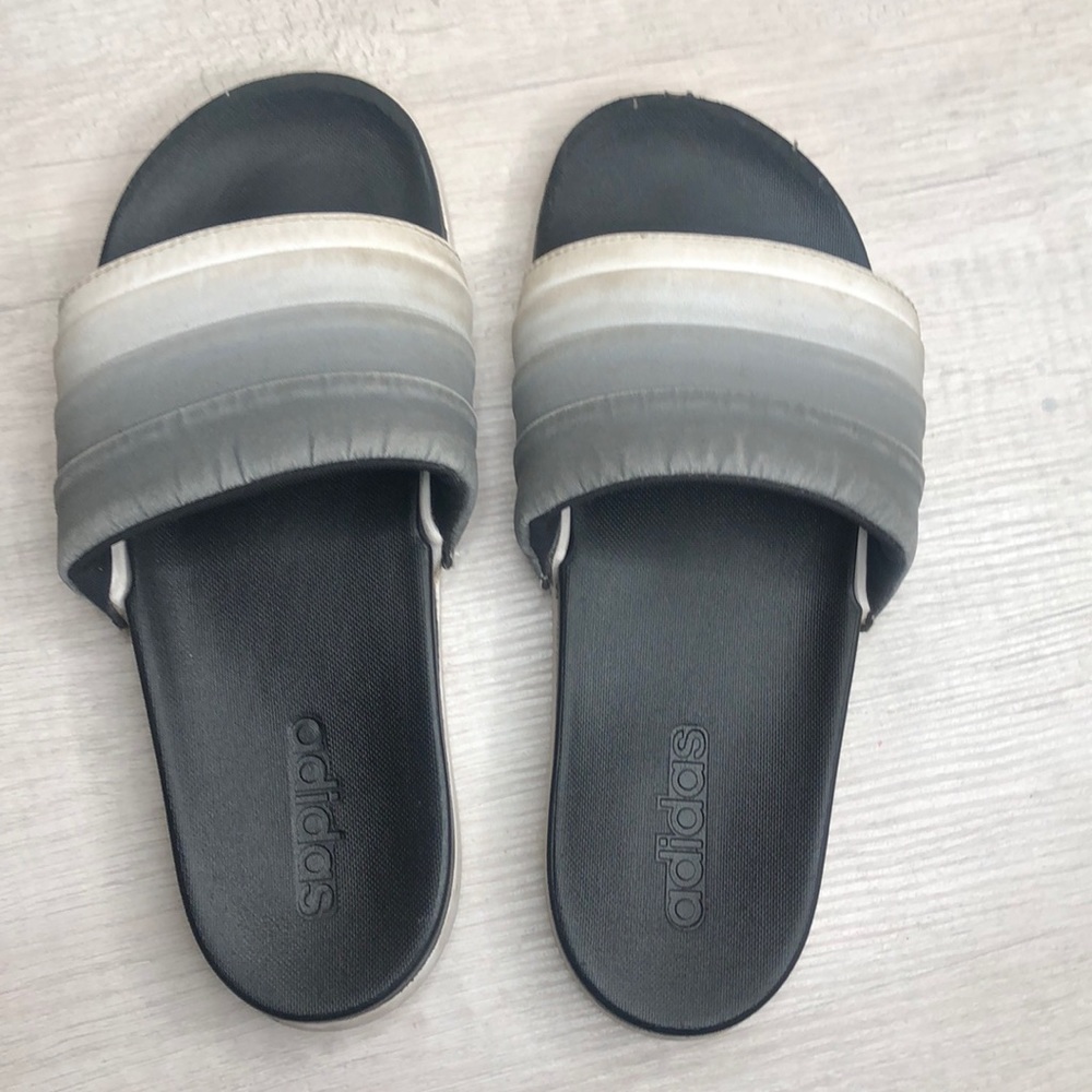 grey and white Adidas slides